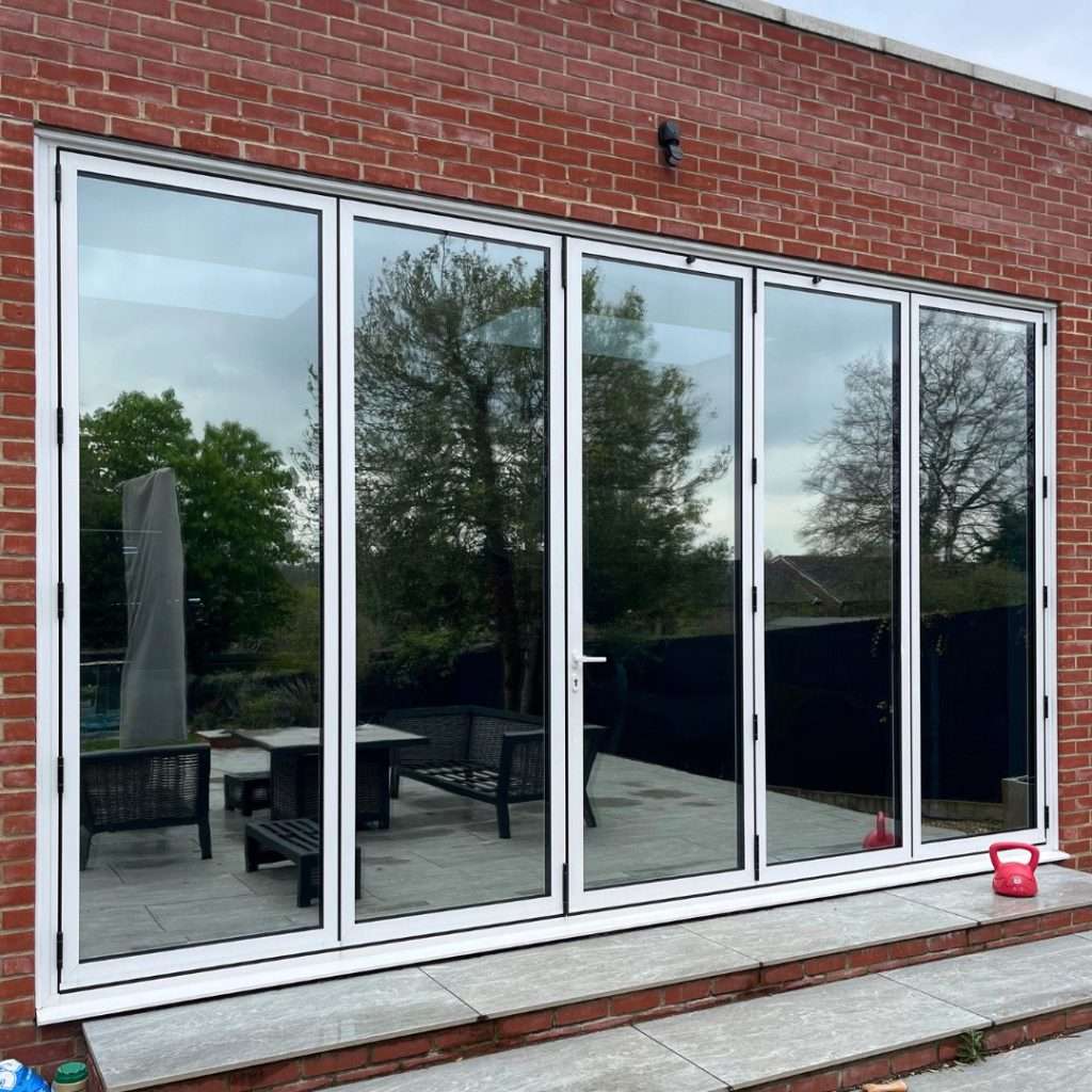Security film combined with Silver 20 reflective solar film applied to bifold doors for strengthened glass, added privacy, and solar control