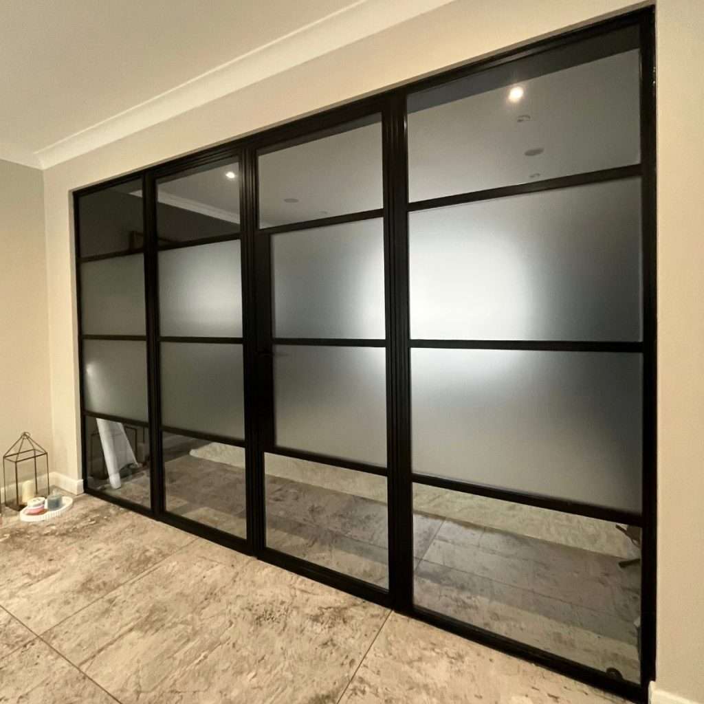 Frosted window film applied to the middle panes of doors, adding privacy while creating a stylish, modern appearance