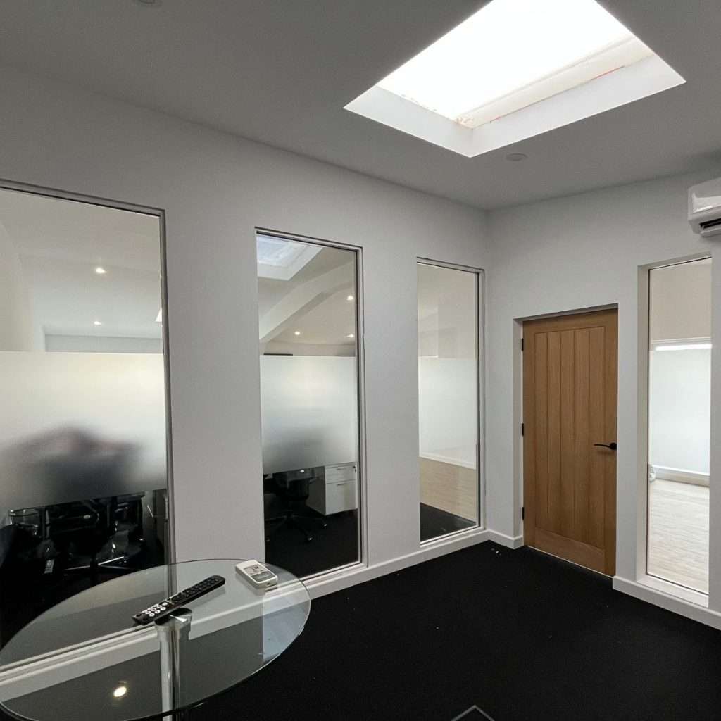 Frosted window film applied to the middle sections of office panes to block views while allowing natural light, creating a sleek and professional look for the workspace