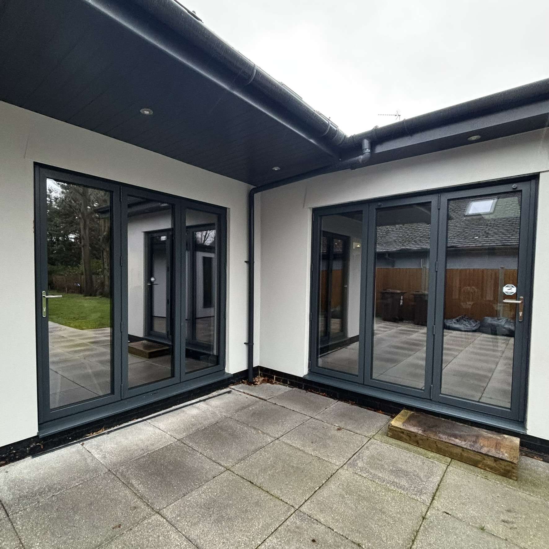 External rear view of a residential property in Colchester with multiple doors fitted with Dual Reflective 35 solar window film, offering subtle privacy and effective heat control.