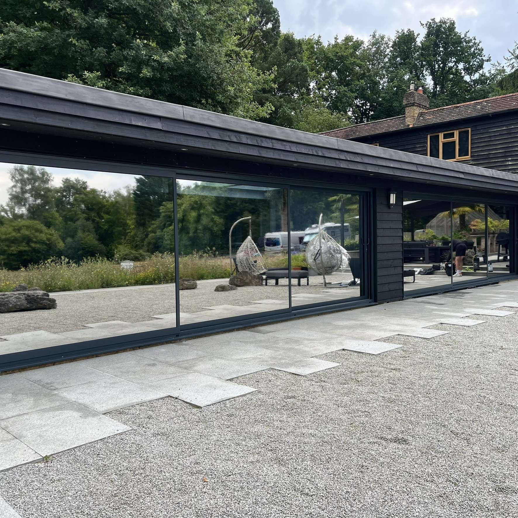 External wide view of large sliding doors in Chigwell fitted with Silver 20 reflective solar window film, enhancing privacy and protecting interiors from UV exposure.