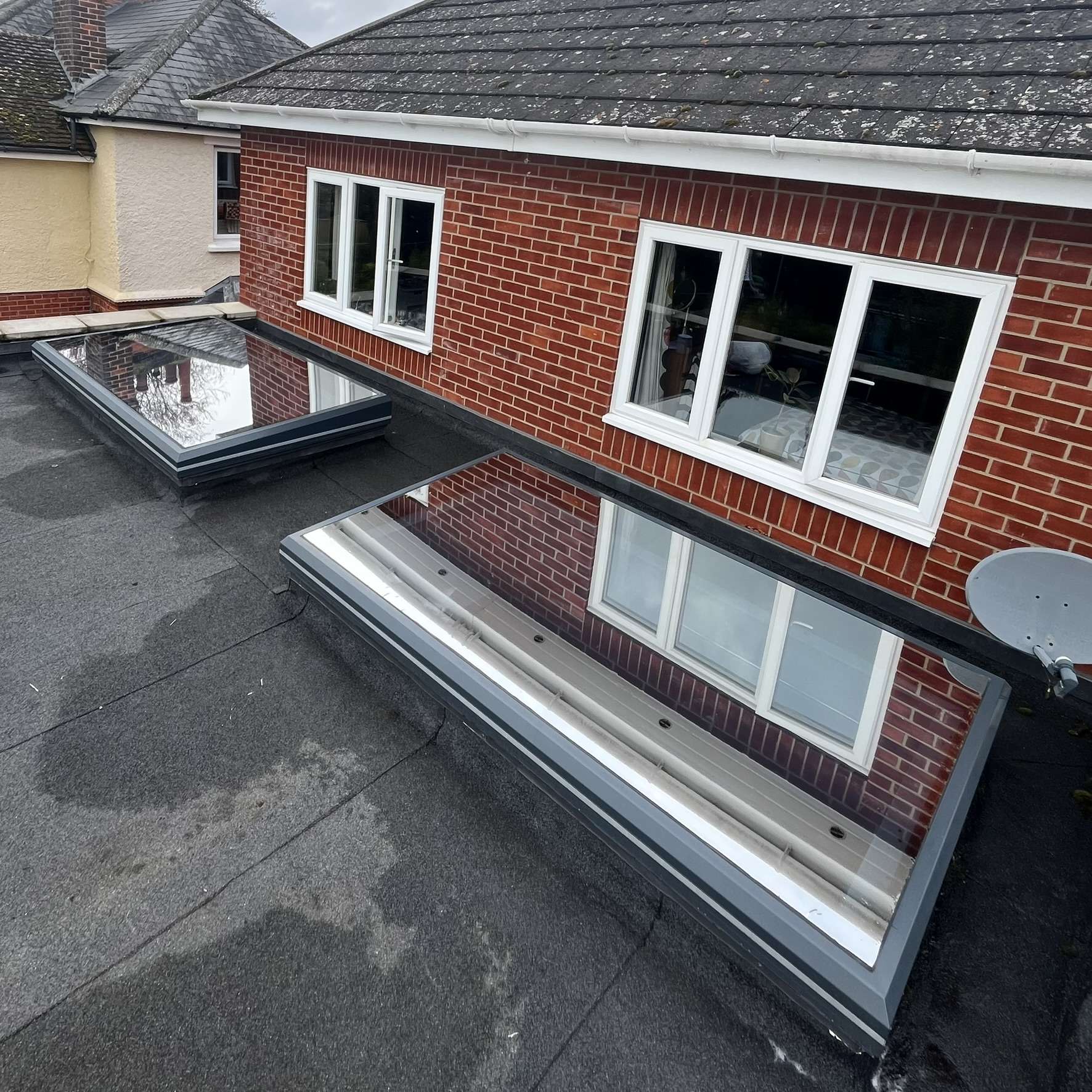 External view of two flat skylights on a Suffolk property fitted with Silver 20 reflective solar window film, reducing heat, glare, and UV exposure while maintaining a sleek appearance.
