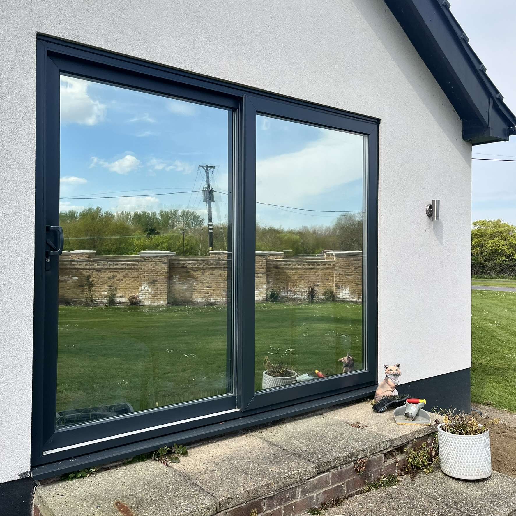 External view of side sliding doors on a Wickford bungalow fitted with Silver 20 reflective solar window film, improving privacy and reducing solar heat entering the home.