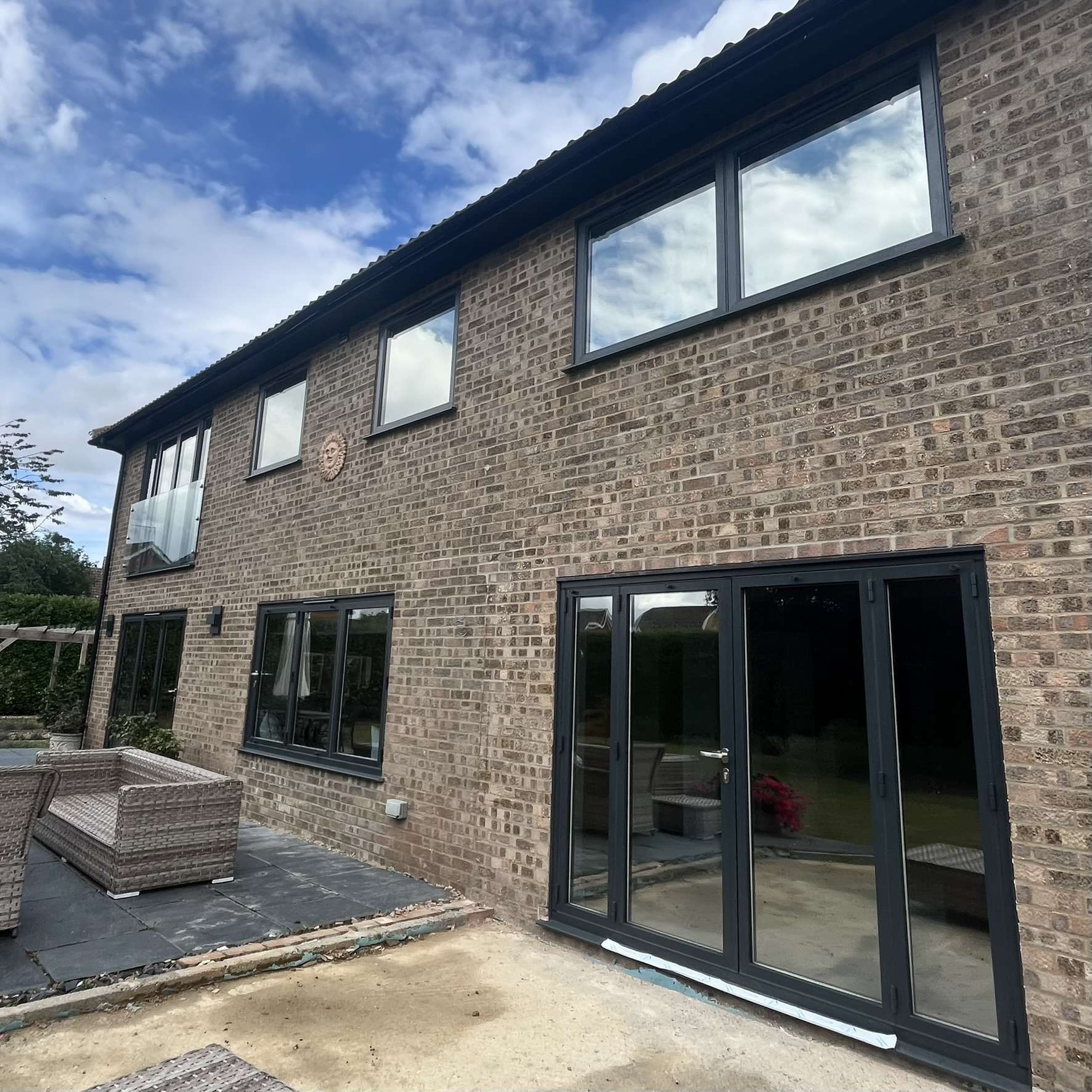External rear view of a residential property in Ipswich showing Silver 35 reflective solar window film installed across the glazing, delivering privacy while helping reduce solar heat and UV exposure.