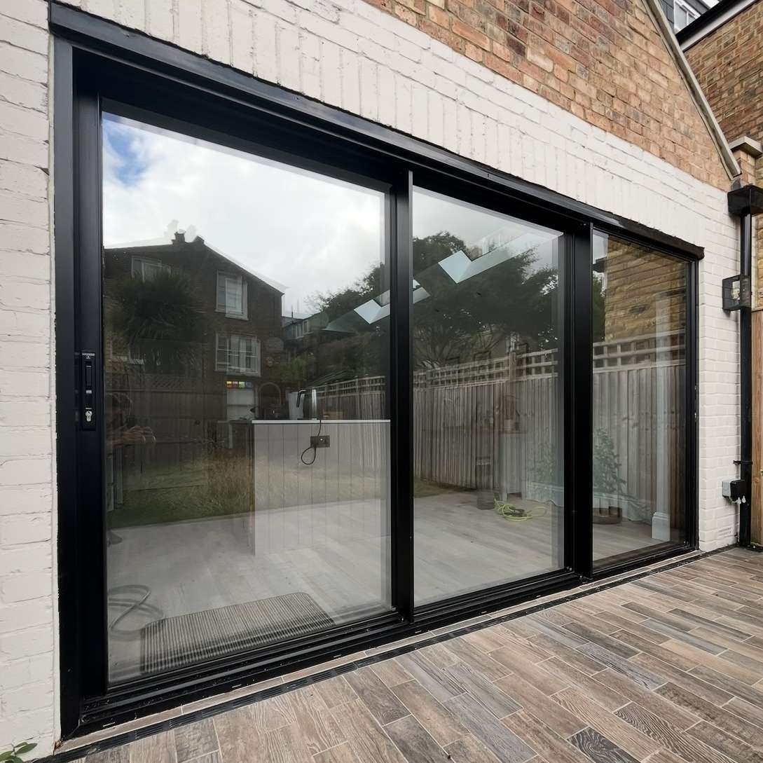 External view of a residential property in Chelsea showing silver 50 reflective solar window film installed on three bifold doors, providing UV protection while maintaining a clean, modern appearance.