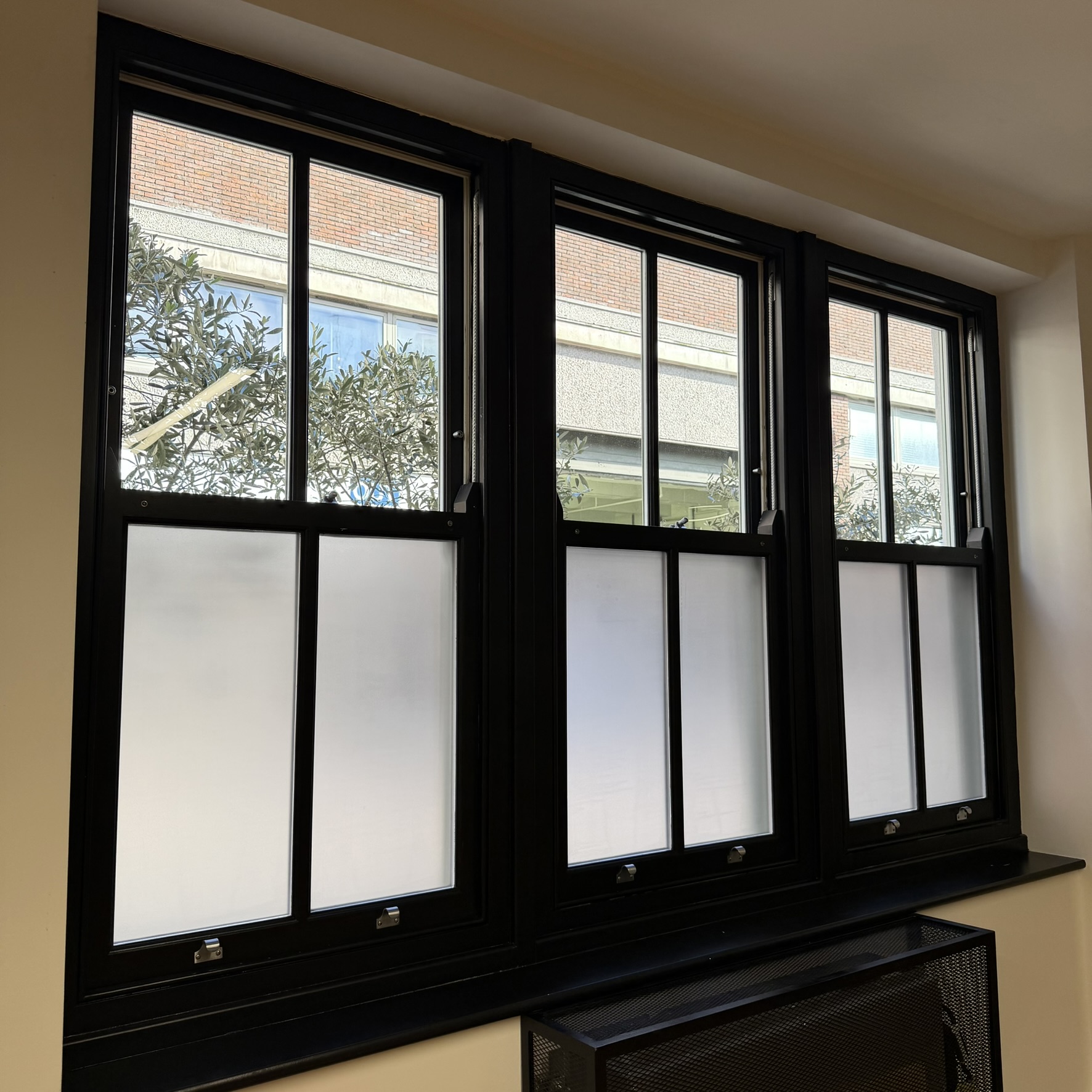 Interior view of an office window in London at 20VC with slate frosted window film applied to the lower glass panels, providing privacy while allowing natural light through the upper glazing.