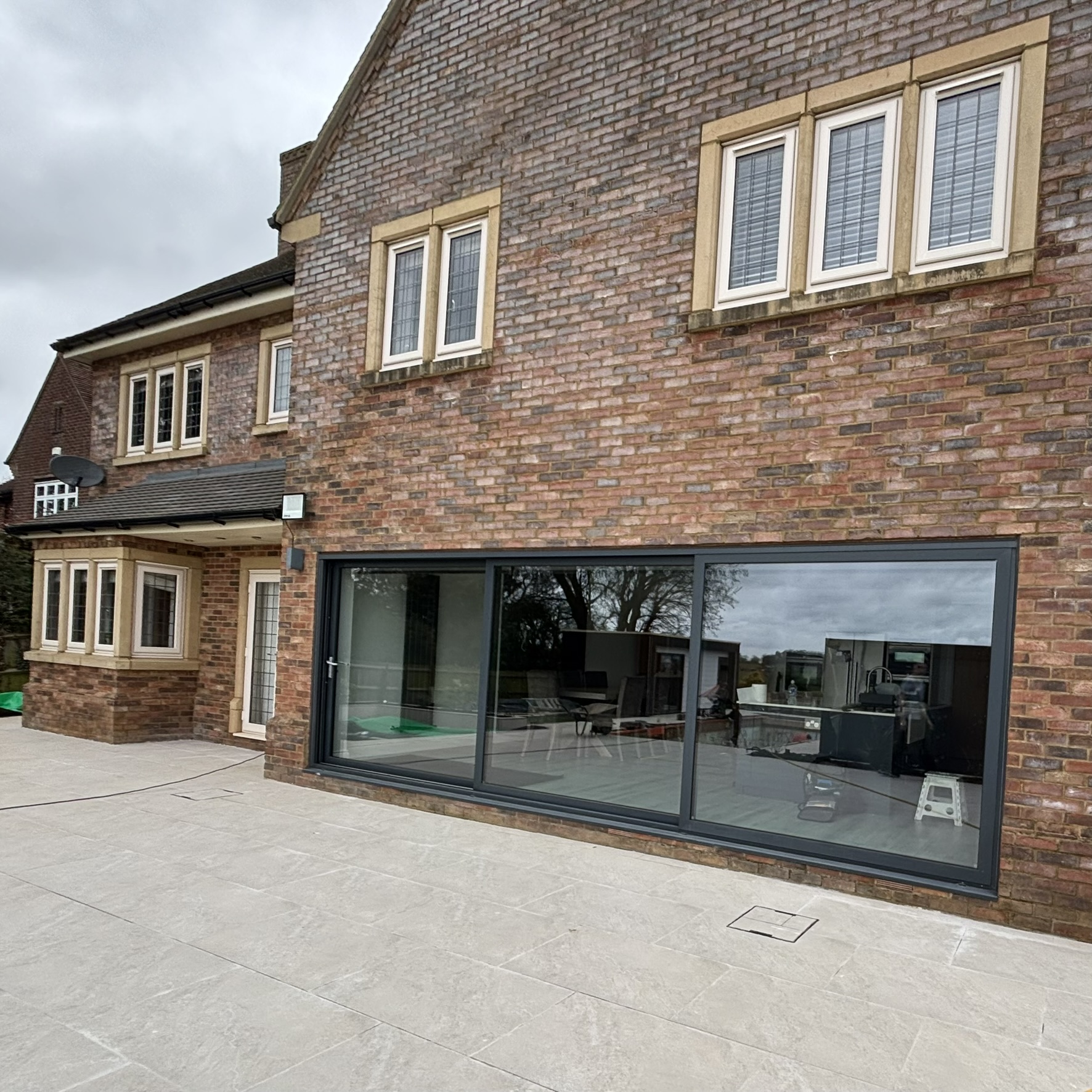 External view of large sliding doors on a residential property in Northampton fitted with specialist clear UV window film, helping prevent interior furnishings from fading.