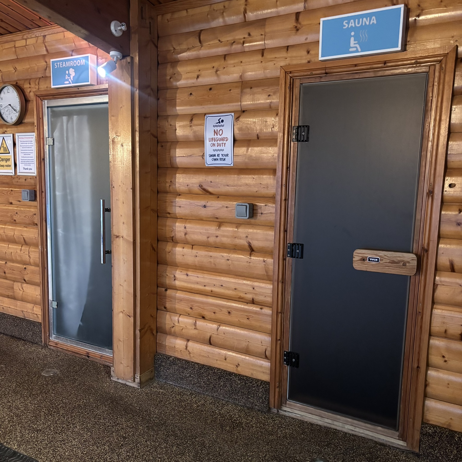 Sauna and steam room doors in a High Wycombe cabin fitted with frosted window film, providing privacy while still letting natural light through.