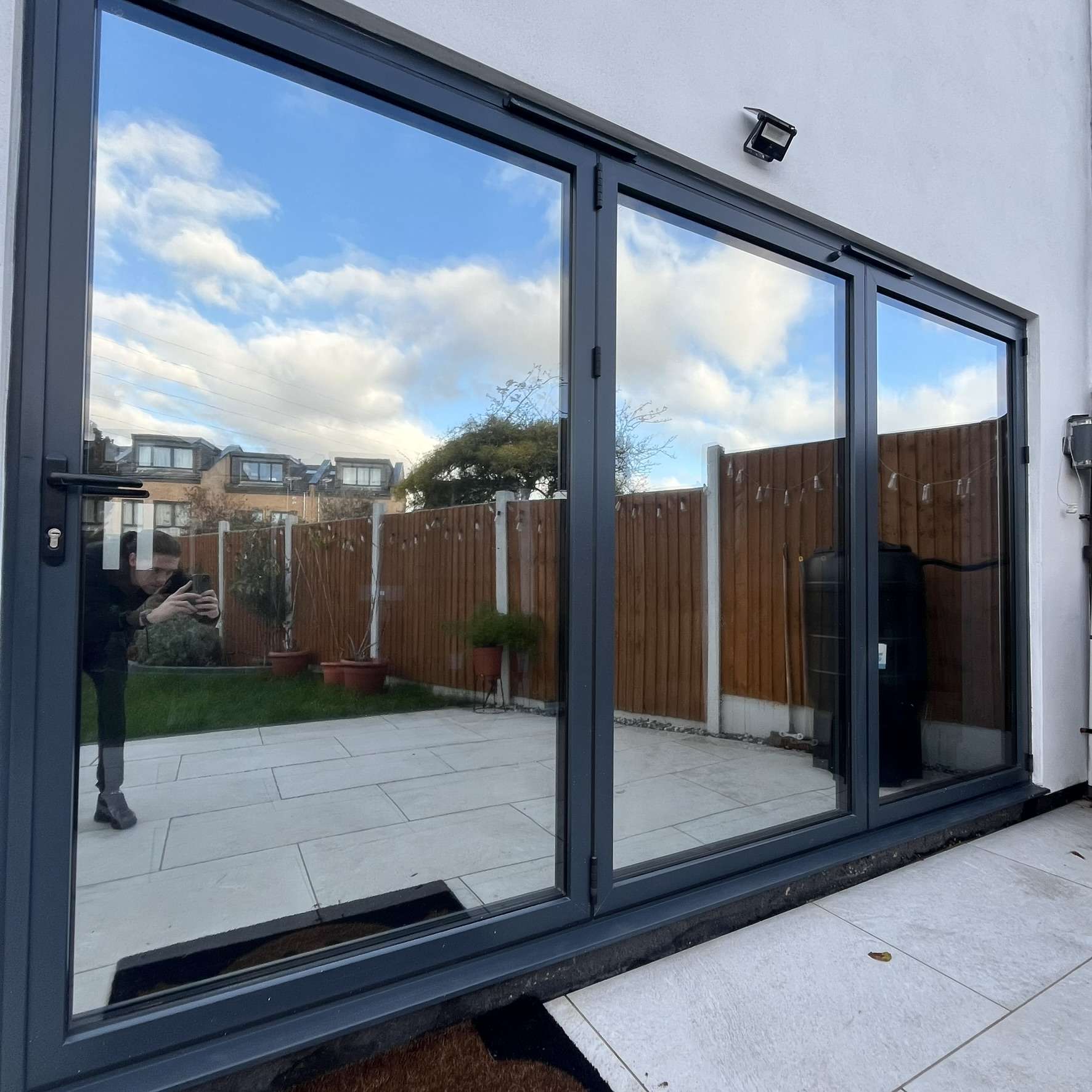 External view of bifold doors in Aveley fitted with Silver 20 reflective solar window film, providing privacy from neighbours and helping block UV exposure.