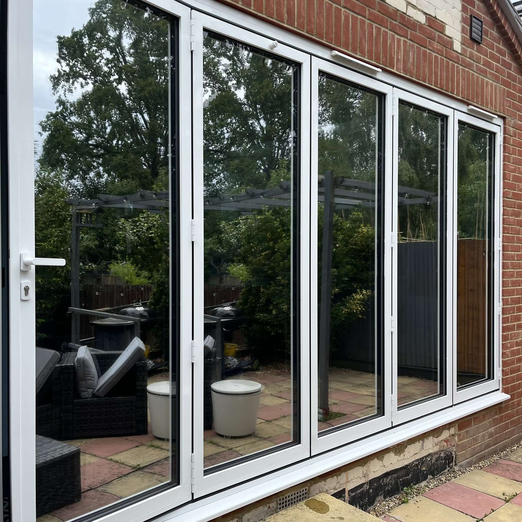 External rear view of a residential property in Bedford with bifold doors fitted with Silver 20 reflective solar window film, providing privacy from overlooking neighbours.