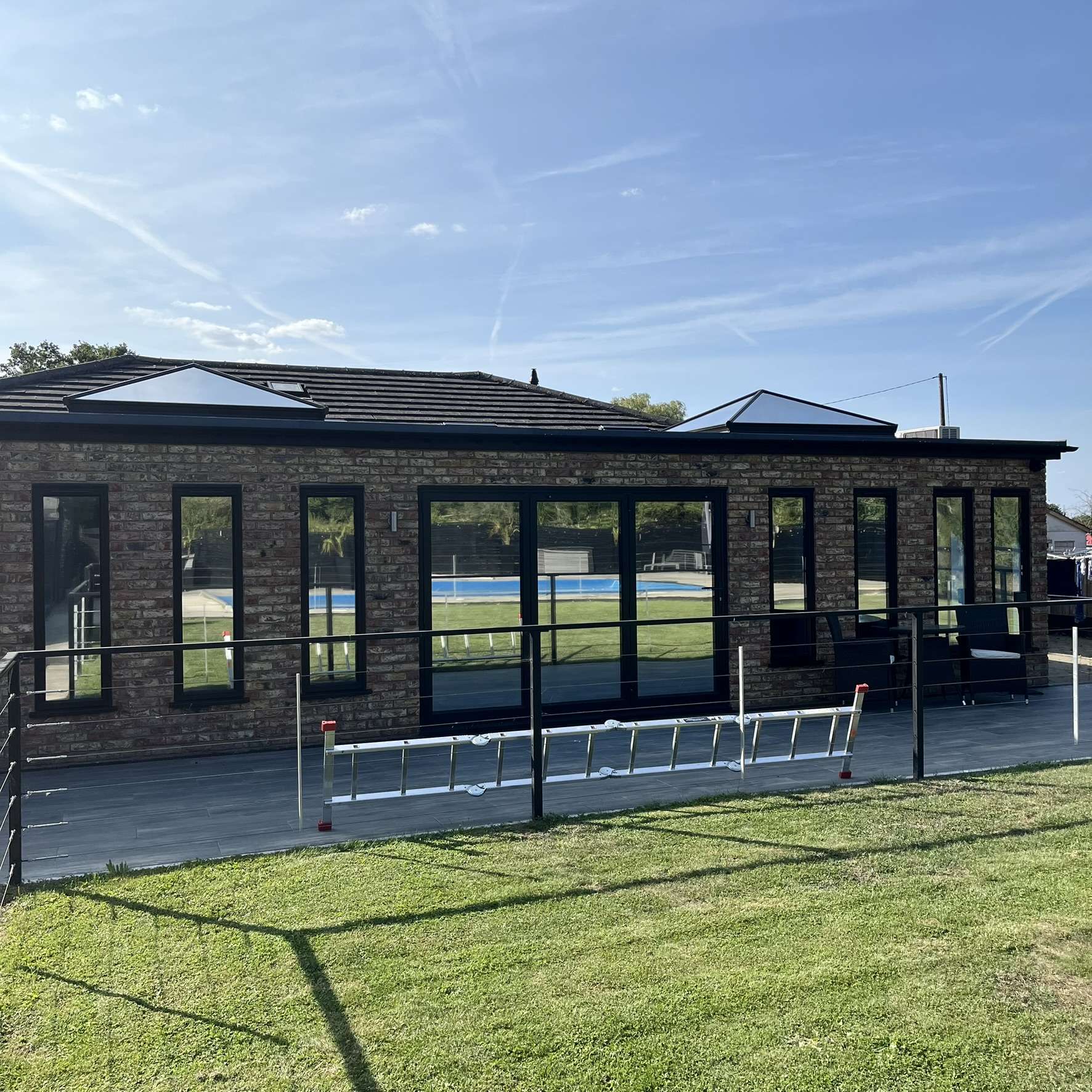 Distant external view of the rear of a large residential property in Benfleet fitted with Silver 20 reflective solar window film, providing privacy and effective solar control.