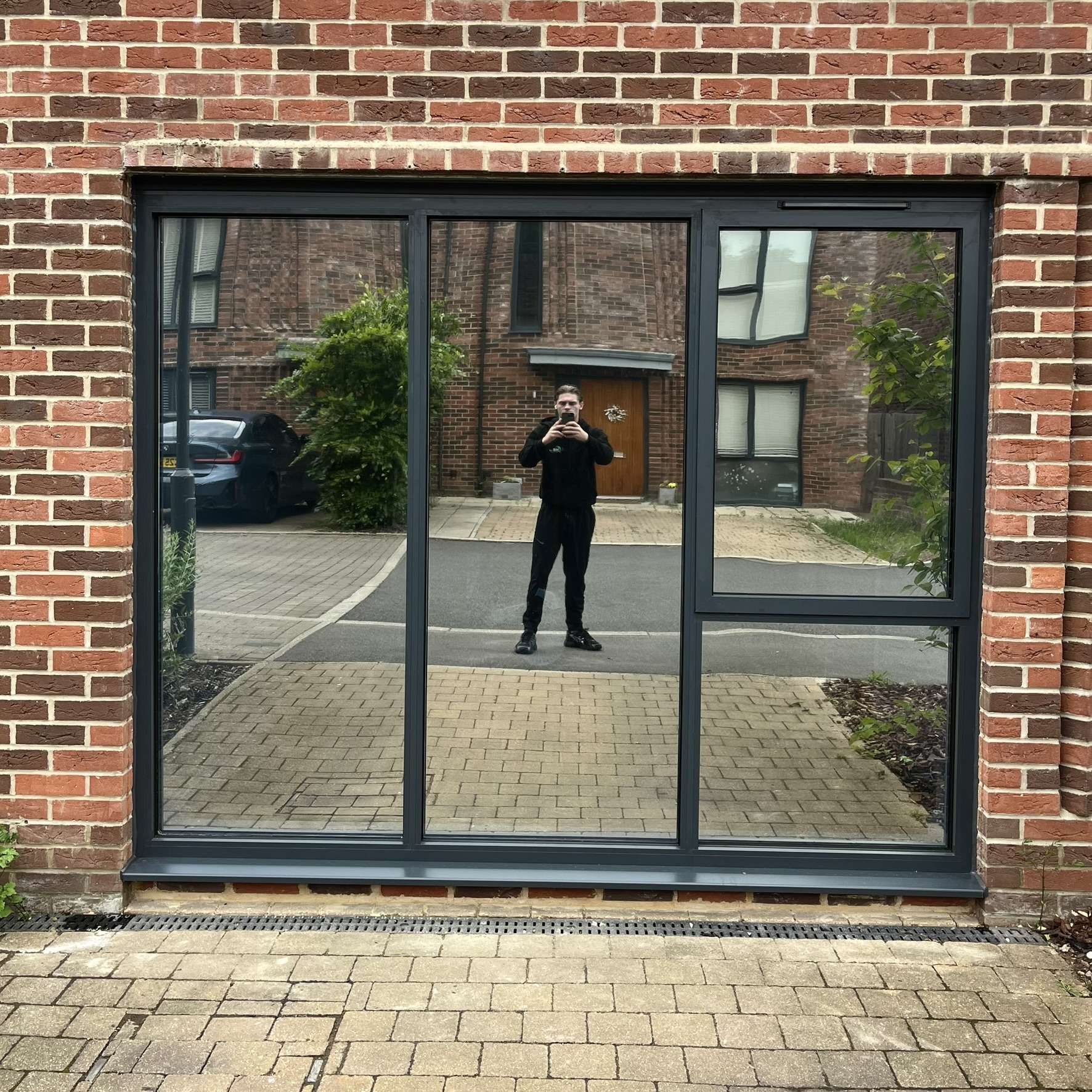 External view of windows in Hackney fitted with Silver 20 reflective solar window film, providing privacy from passers-by along a nearby pathway.
