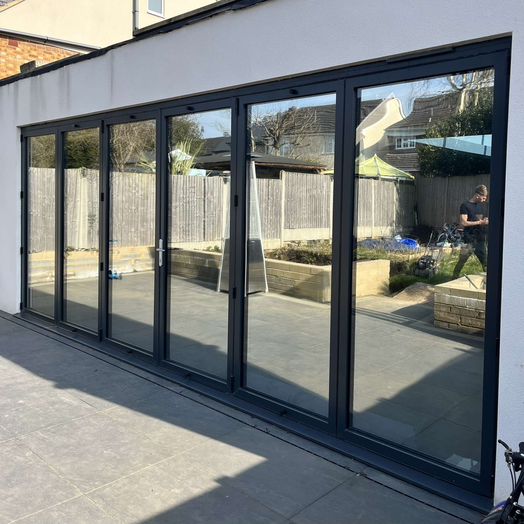 External view of large bifold doors at the rear of a Hertfordshire property fitted with Silver 20 reflective solar window film, providing privacy from neighbours and UV protection.