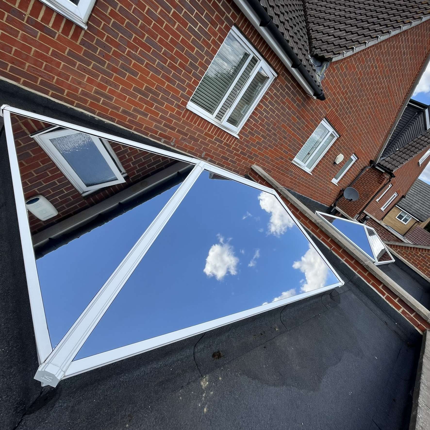 External view of roof skylights in Hornchurch fitted with external Silver 20 reflective solar window film, providing year-round reduction of heat, glare, and UV.