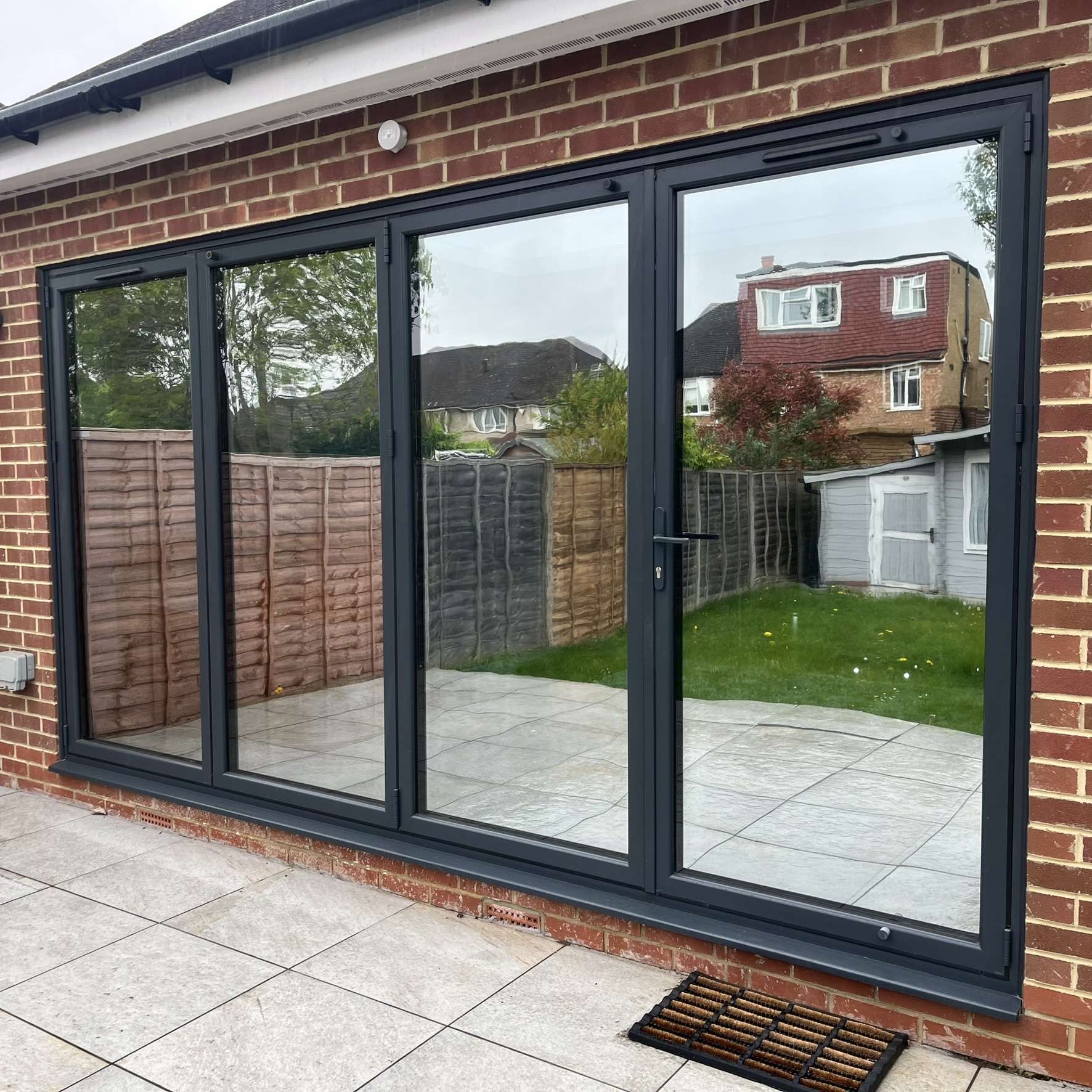External view of bifold doors in Oxford fitted with Silver 20 reflective solar window film, helping reduce heat gain and protect interiors from UV rays.