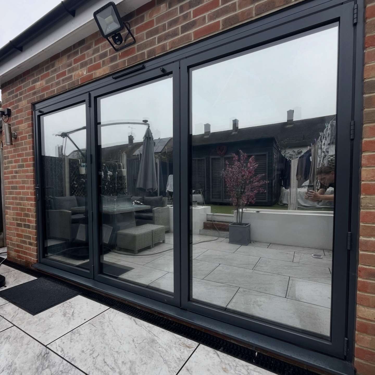 External view of bifold doors in South Ockendon fitted with Silver 20 reflective solar window film, improving privacy from nearby neighbours while reducing glare.