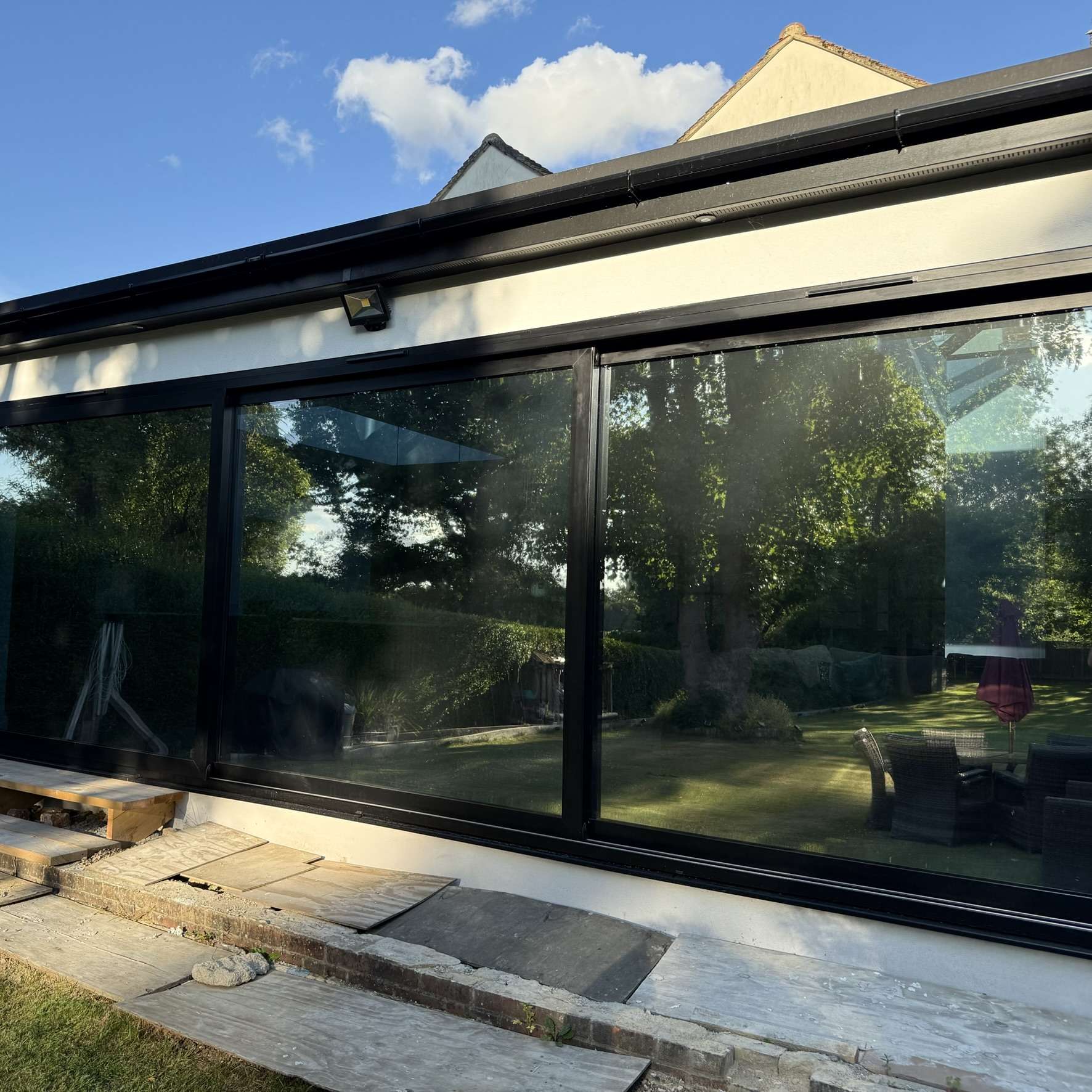 External view of large sliding doors in Upminster fitted with Silver 20 reflective solar window film, enhancing privacy while helping manage solar heat.