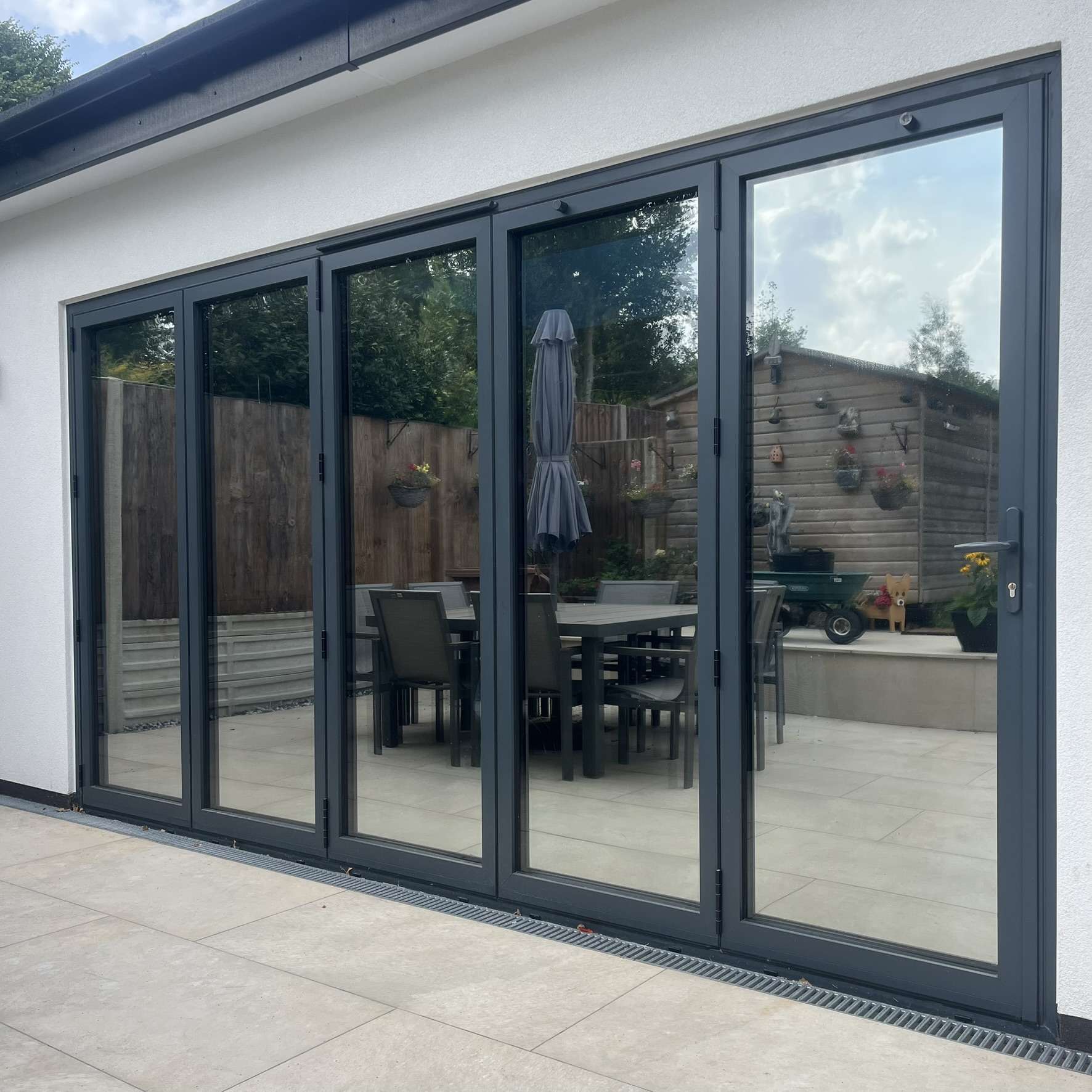 External view of bifold doors in Watford fitted with Silver 20 reflective solar window film, improving privacy from neighbours while helping protect against UV exposure.