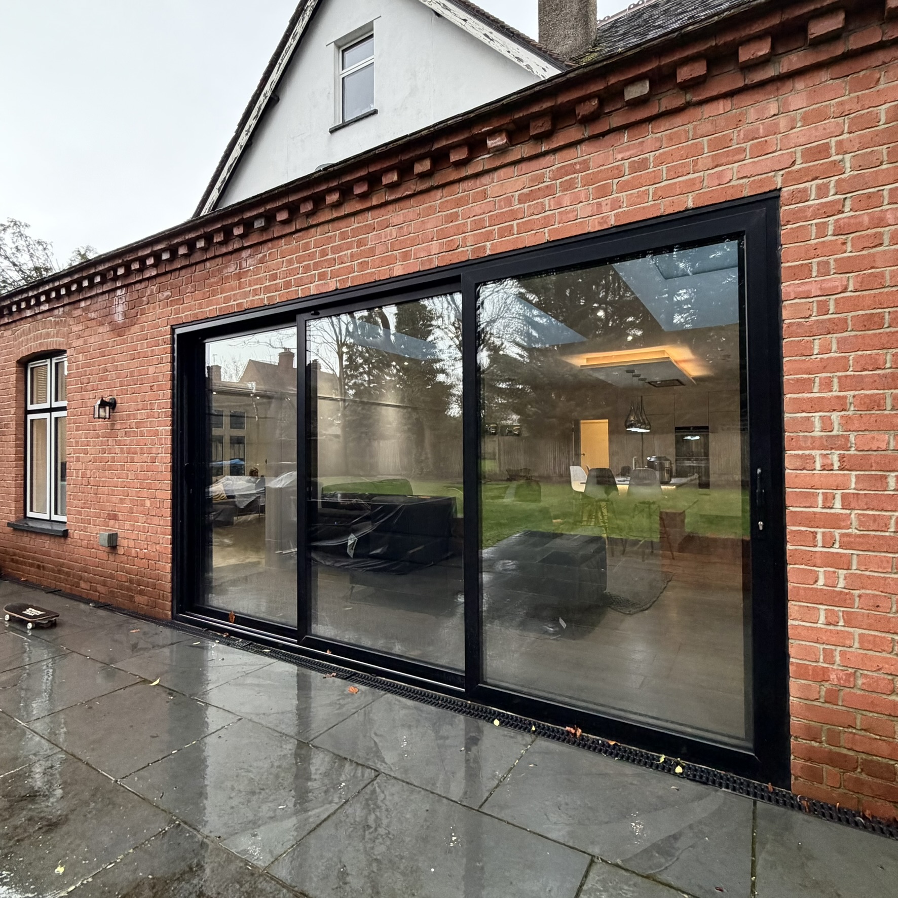 External view of bifold doors in Ruislip fitted with Silver 50 reflective solar window film, supporting year-round solar control with a subtle, modern appearance.