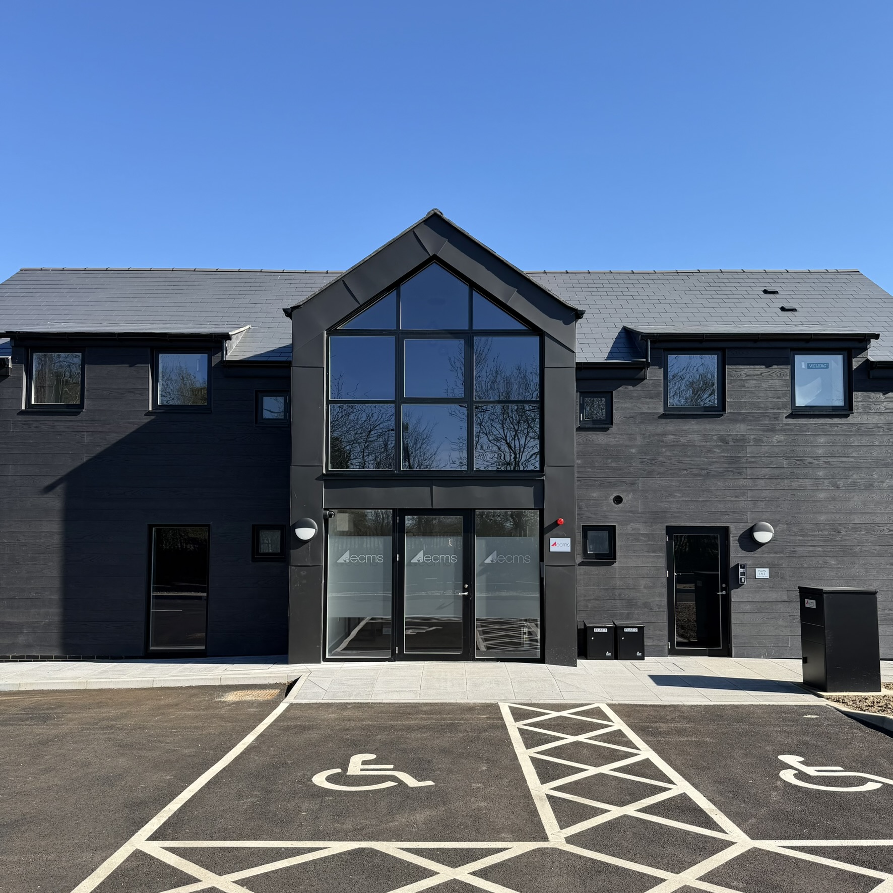 Distant external view of a large office complex in Sevenoaks fitted with Slate 35 tinted solar window film, helping create a more comfortable working environment with glare reduction and heat control.