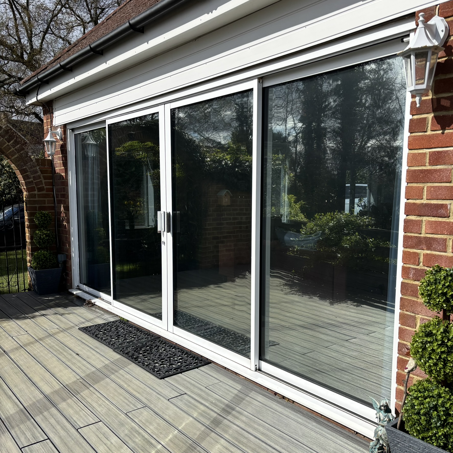 External view of bifold doors in Guildford fitted with Silver 20 reflective solar window film, providing privacy and year-round heat control.