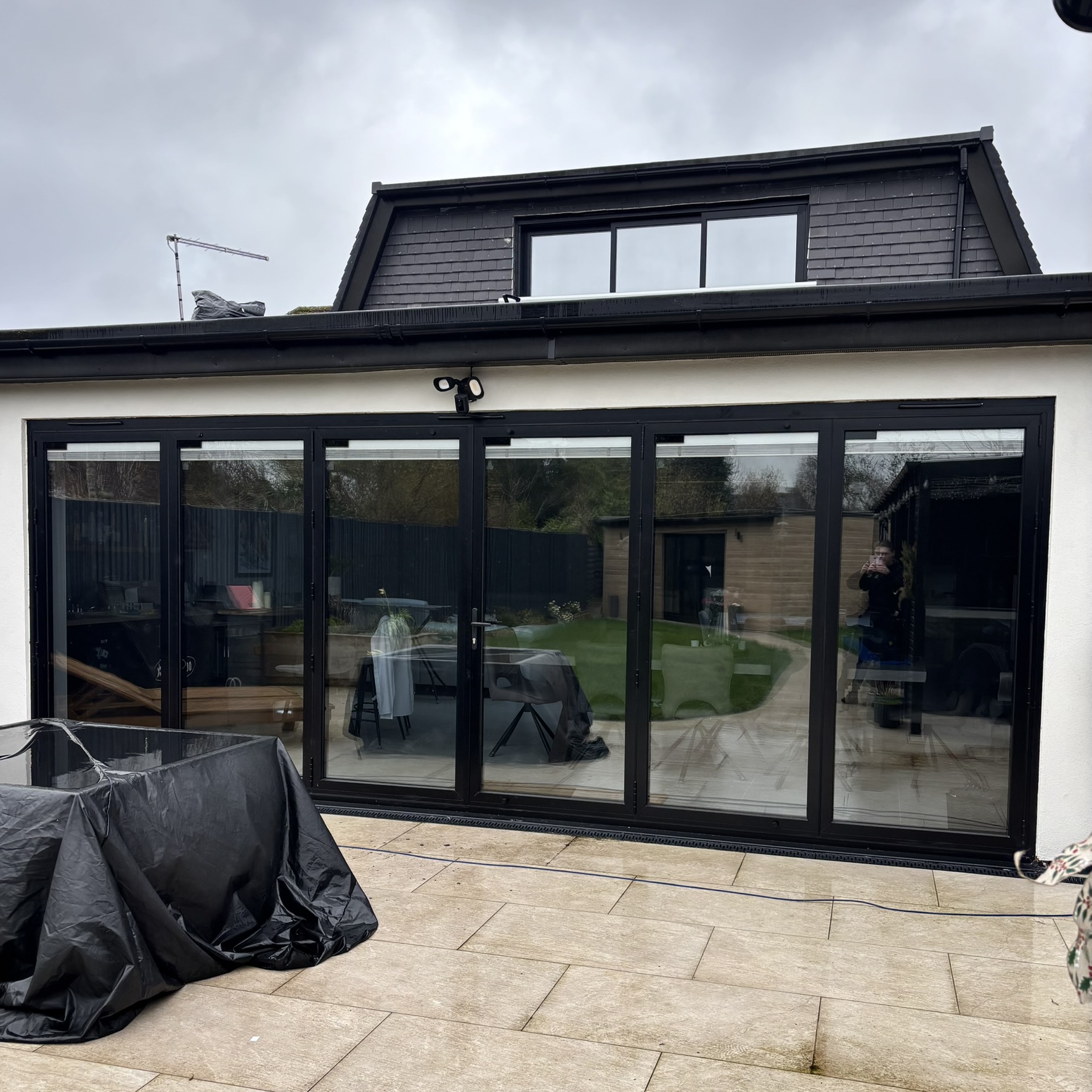 External view of six bifold doors in Harrow fitted with Silver 20 reflective solar window film, providing daytime privacy and improved energy efficiency.