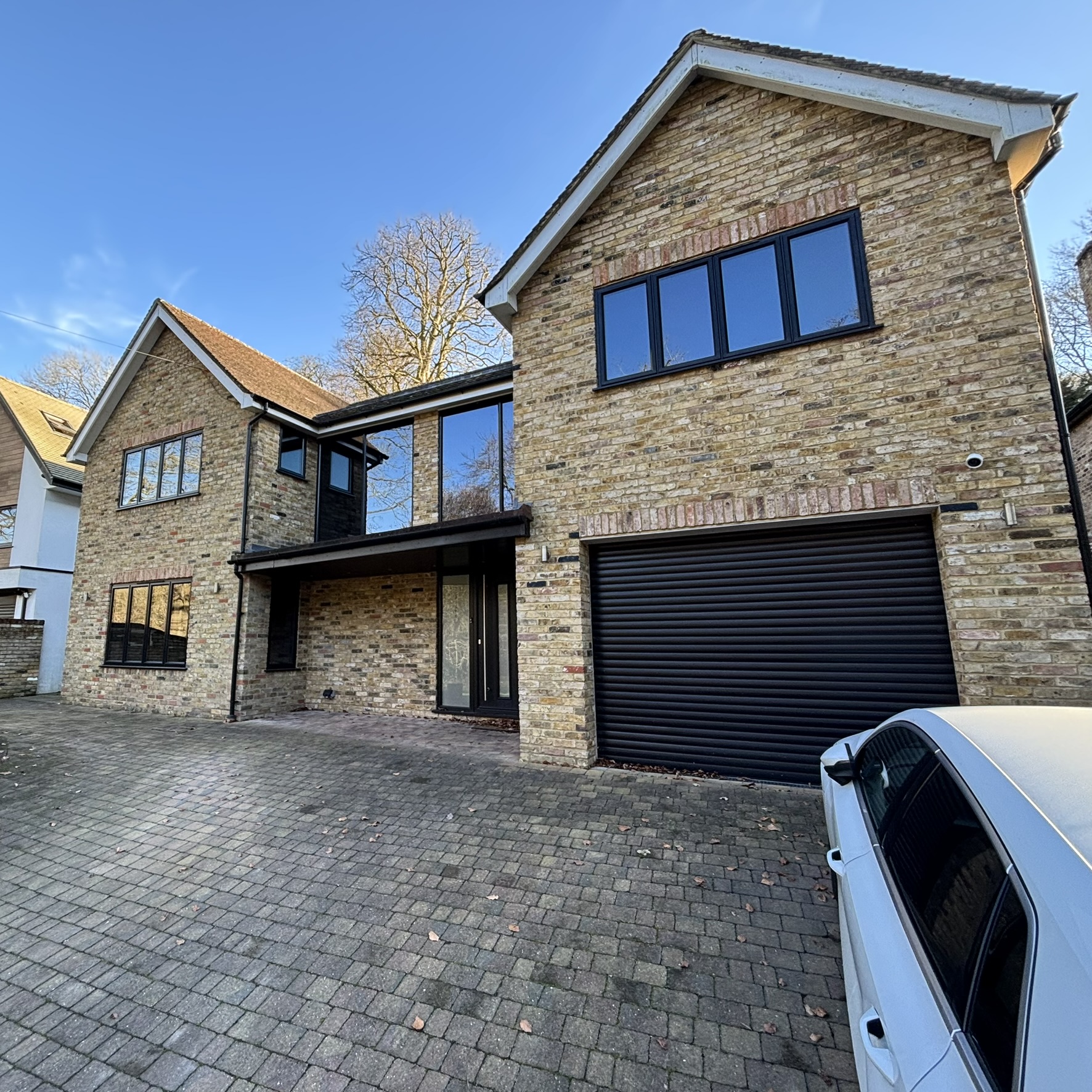 External front view of a large property in Watford fitted with Slate 20 tinted solar window film, giving the building a sleek appearance while providing daytime privacy from passers-by.