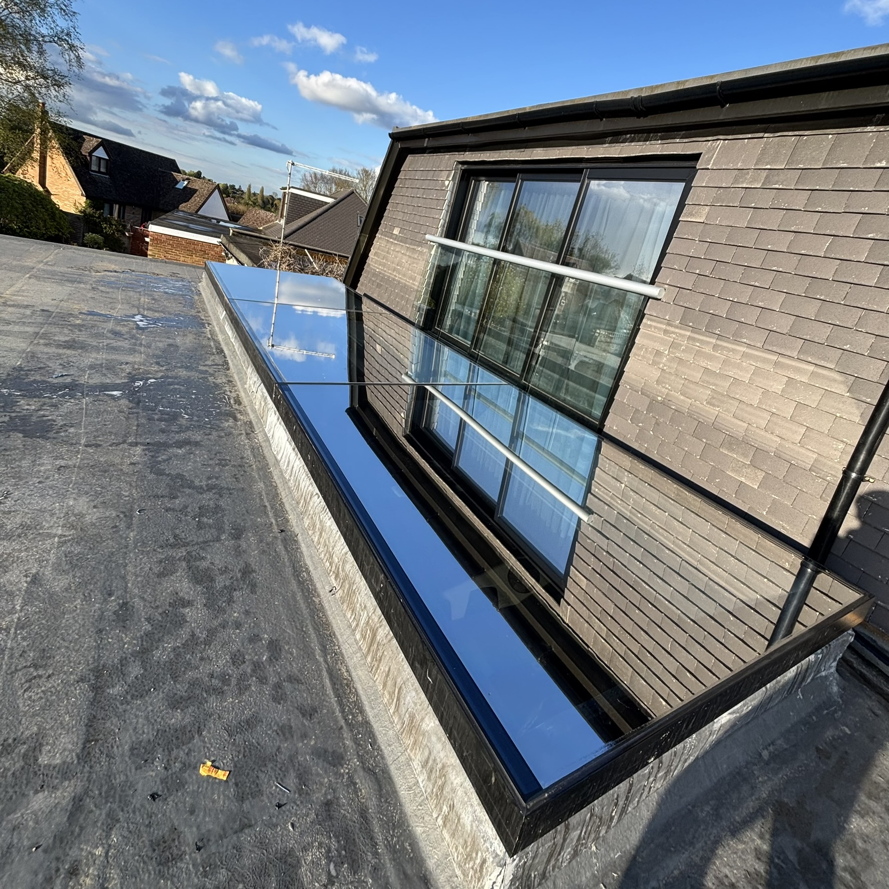 External view of three skylights and three sliding doors in Harrow fitted with Silver 20 reflective solar window film, providing year-round solar control with reduced heat, glare, and UV exposure.