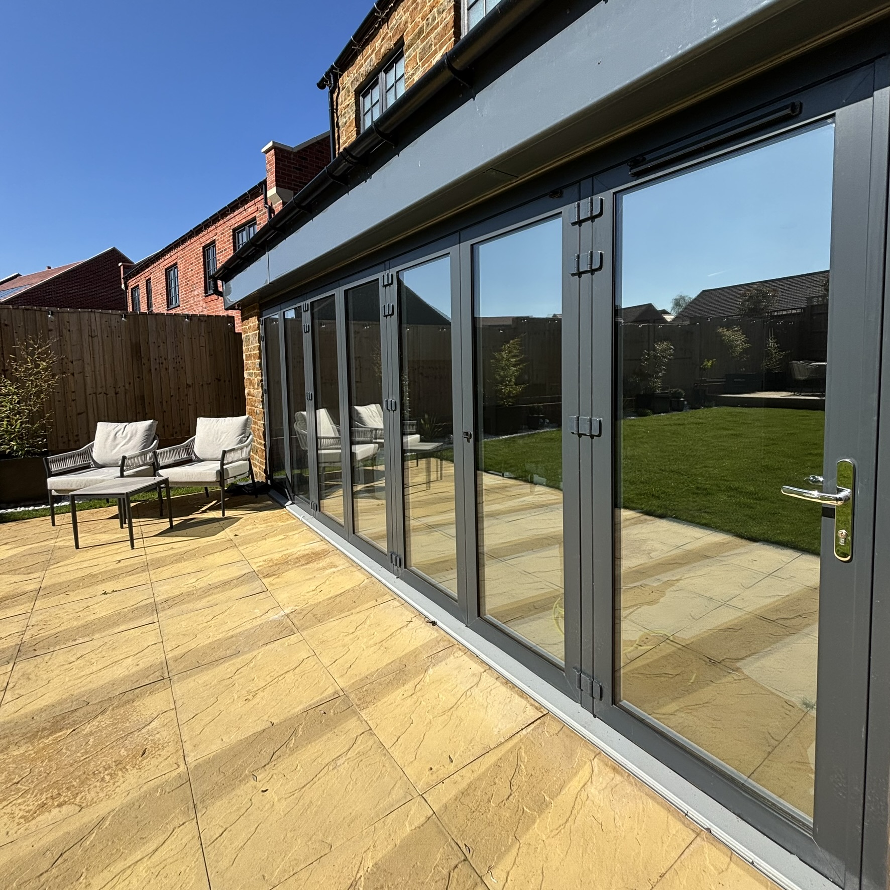 External view of bifold doors in Adderbury fitted with Silver 35 reflective solar window film, providing a sleek finish while helping improve heat control.