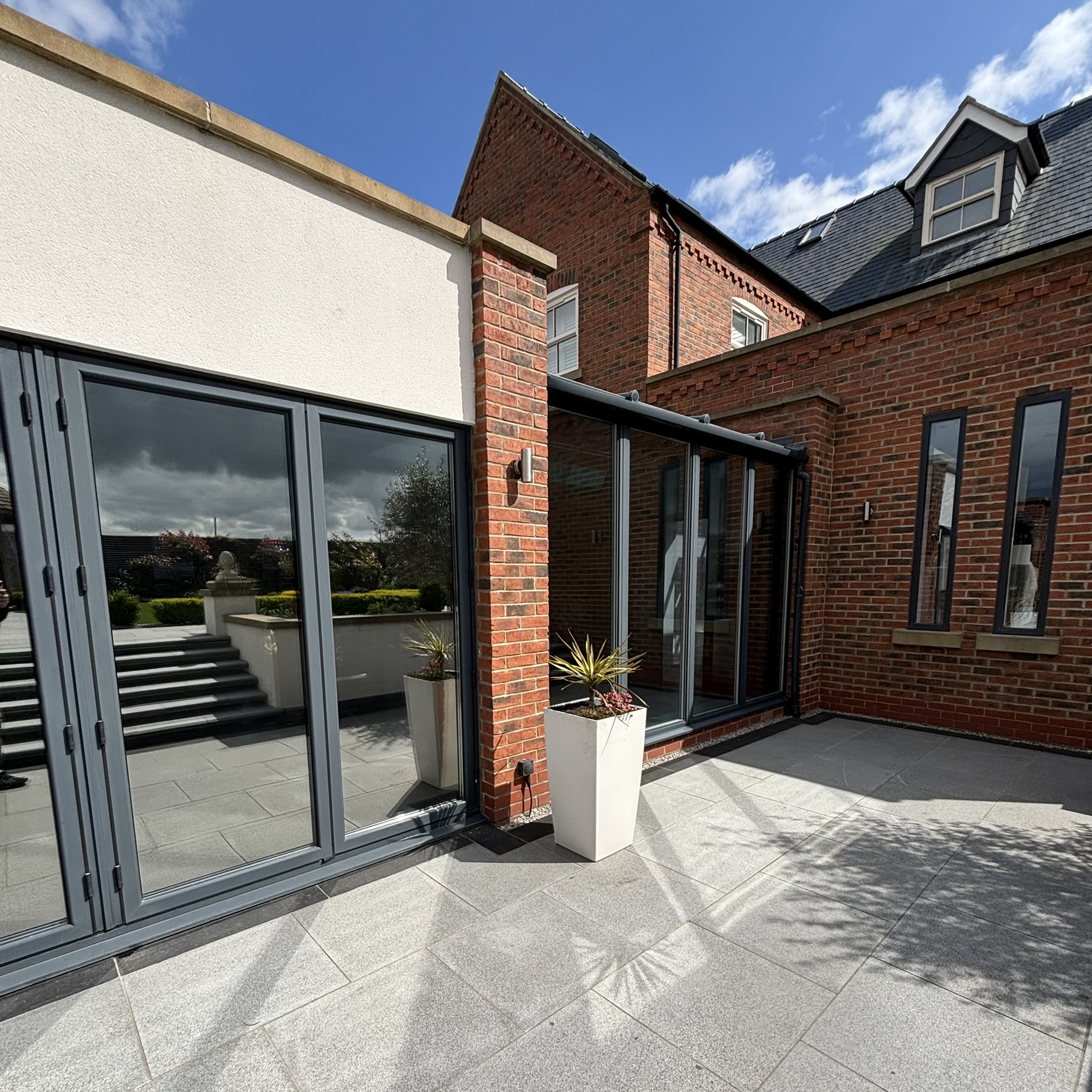 External angled view of large doors and bifold doors in Louth fitted with Silver 35 reflective solar window film, creating a sleek finish while improving energy efficiency.