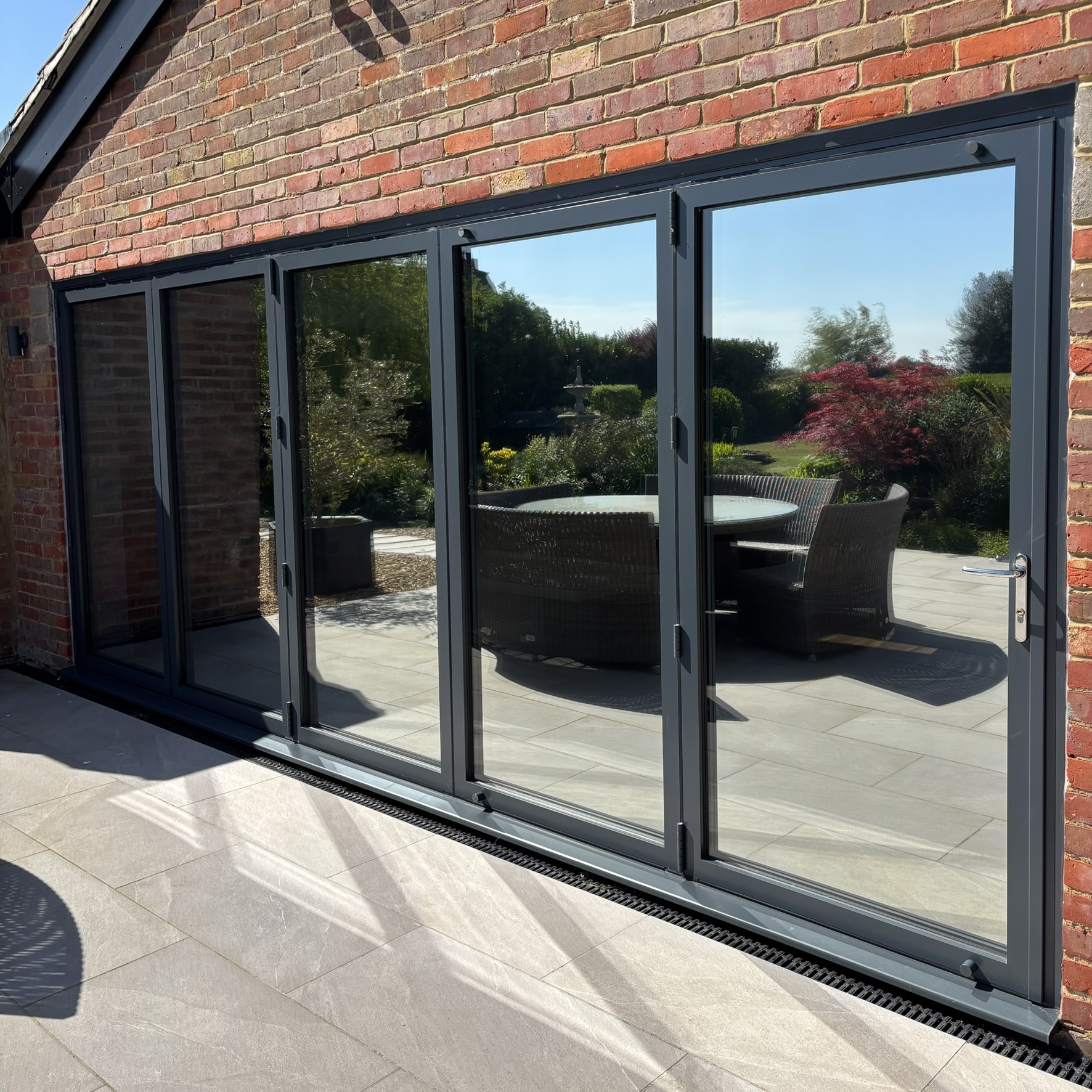 External view of a set of bifold doors in Brickhill fitted with Silver 20 reflective solar window film, enhancing privacy and helping protect interiors from UV exposure.
