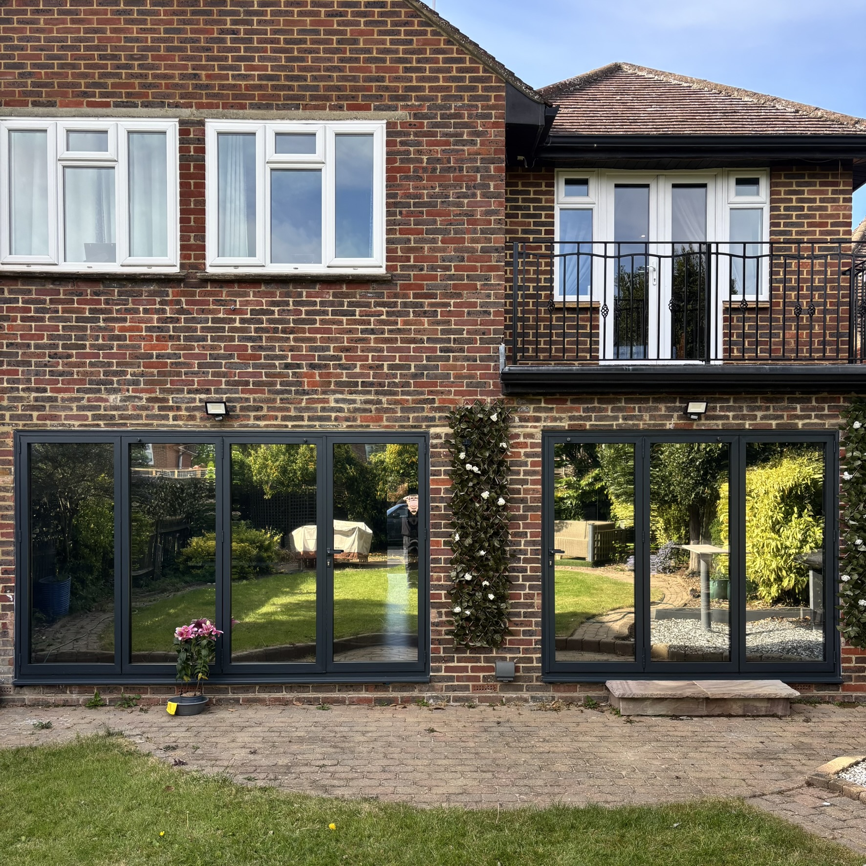 External view of two sets of bifold doors in Sunbury-on-Thames fitted with Silver 20 reflective solar window film, providing improved year-round solar control.