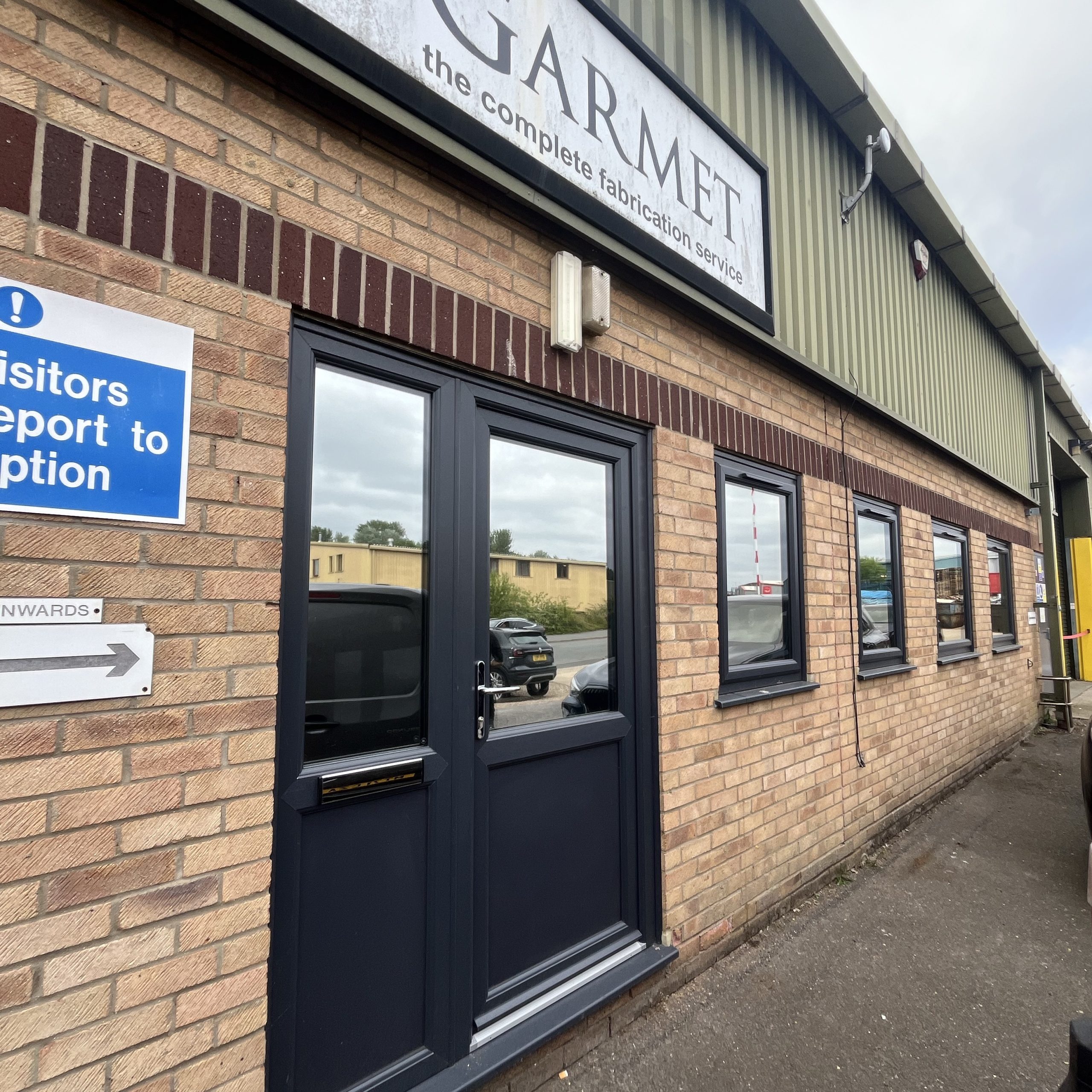 External view of a commercial warehouse in Thetford, Norfolk, fitted with Silver 20 reflective solar window film across the glazing to improve working comfort and provide daytime privacy.