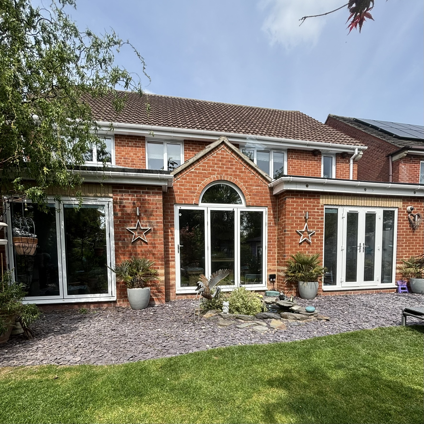 External rear view of a residential property in Andover, Hampshire, fully fitted with Silver 20 reflective solar window film for daytime privacy from neighbours, heat control, and UV protection.